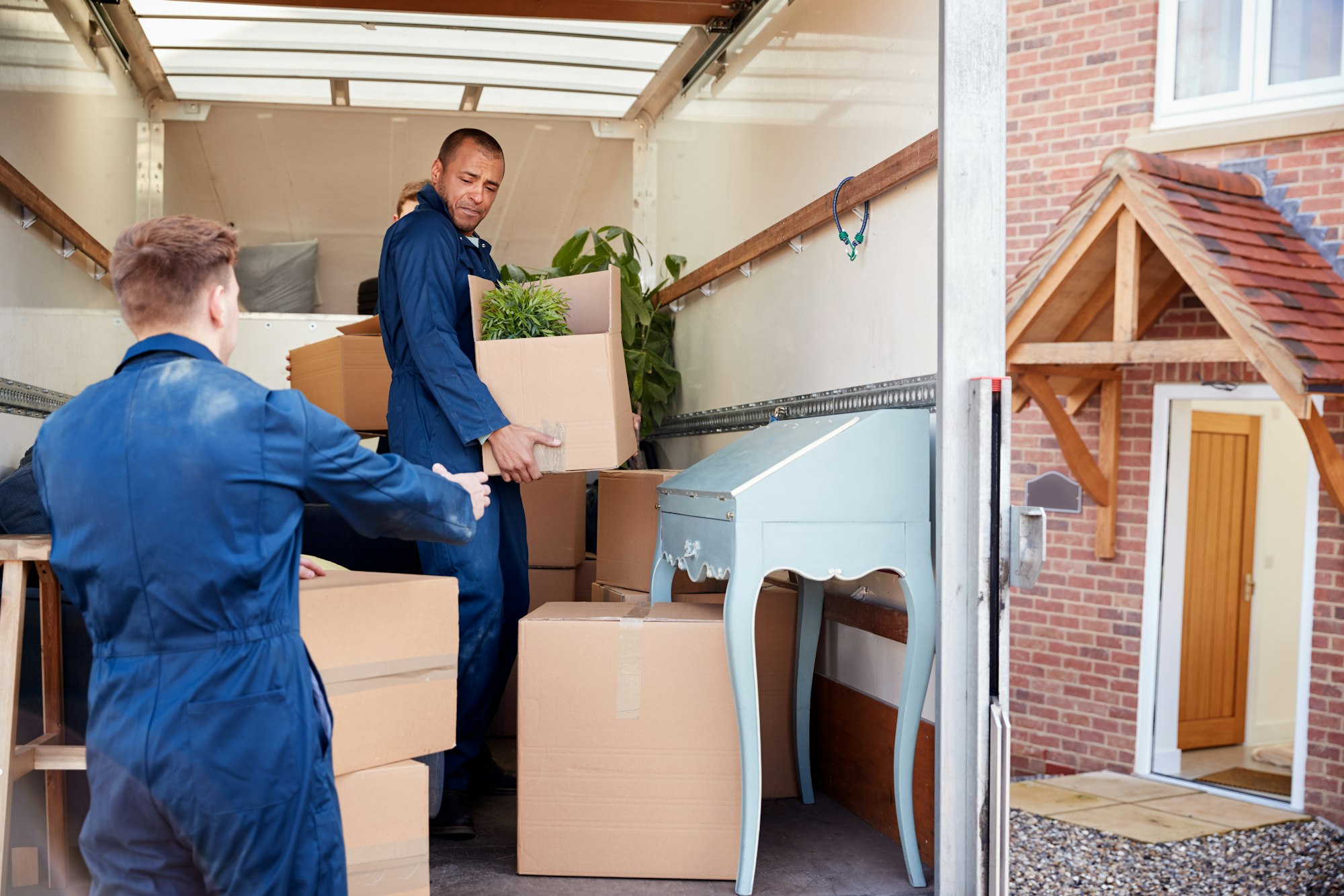 Moving company employee checks boxes in a small truck before sending them to the homeowner.